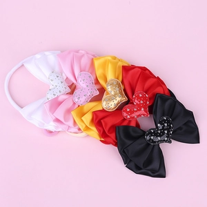 Detail of five colorful nylon baby headbands featuring glossy satin bows with sequin hearts