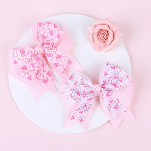 Détail de pinces à cheveux roses multicouches avec motifs cœurs et LOVE pour filles