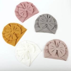 Flat lay of five baby waffle knit bow turbans in pink, grey, yellow, and white colors