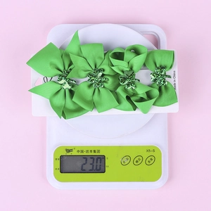 Detail view of 4-piece St. Patrick's clover hair bows set weighing 23g on scale