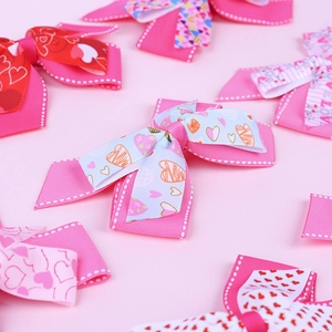 Detail of pink grosgrain ribbon hair bows with gold heart patterns and LOVE prints