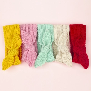 Détail de bandeaux tricotés pour bébé en cinq couleurs avec de gros nœuds décoratifs