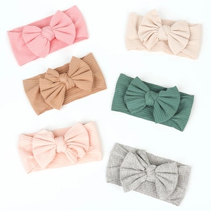 Close-up of six soft cotton ribbed bow headbands for babies in assorted pastel colors