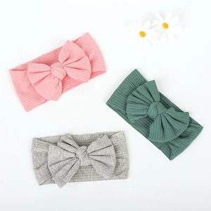 Three-piece set of ribbed cotton baby headbands with large bows in pink, green, and grey
