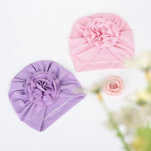 Dettaglio dei cappellini a turbante per neonati in maglia morbida con grandi fiori