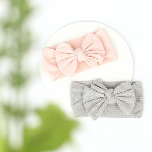Close-up of pink and grey ribbed cotton baby headbands with oversized knot bows