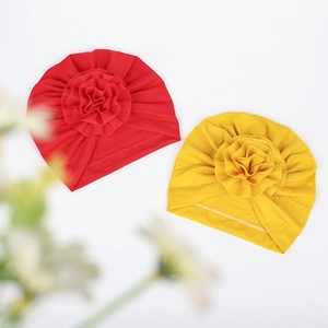 Dettaglio di turbanti per neonati rossi e gialli con grandi fiori 3D e maglia morbida