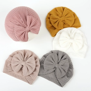 Five-color infant waffle knit beanies with large bows in pink, yellow, white, apricot, and gray