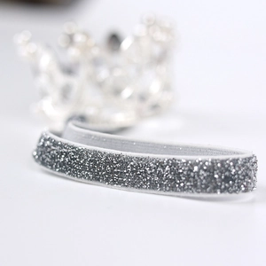 Makro-Detail von silber glitzerndem elastischem Haarband für Baby-Prinzessin-Geburtstage