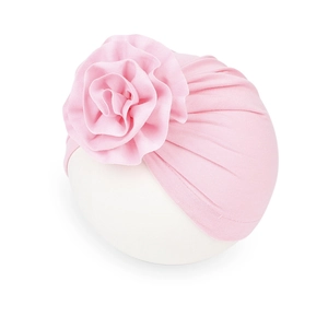 Dettaglio del cappello a turbante rosa per neonati con grande fiore e trama pieghettata