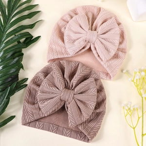 Détail de bonnets turban pour bébé avec grands nœuds en tissu tricoté rose et marron