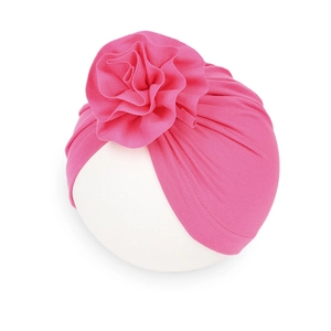 Dettaglio del cappello turbante rosa per neonati con un grande fiore 3D in tessuto
