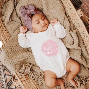 Détail du turban bébé avec texture ajourée et grand nœud en rose poudré