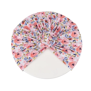 Vue détaillée du turban à imprimé floral rose avec un détail de nœud donut décoratif