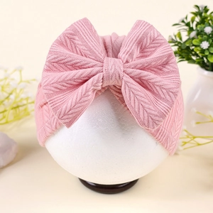 Vue détaillée d'un turban bébé rose avec motif à chevrons et grand nœud décoratif