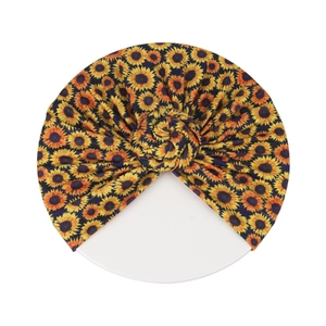 Détail de l'imprimé tournesol sur turban pour bébé bleu foncé avec nœud donut
