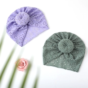 Detailed close-up of baby turban hats with eyelet lace fabric and donut knot design