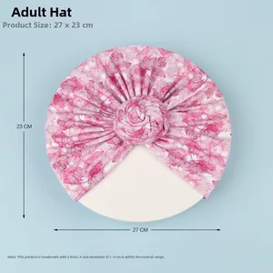 Vue à plat d'un turban à fleurs roses avec nœud fait main, dimensions 27x23cm