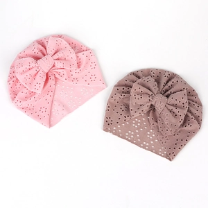 Détail de bonnets turban pour bébé avec grands nœuds et broderie anglaise respirante en deux couleurs