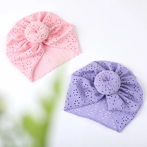 Detail view of breathable lace hollow-out baby turban hats in pink and lavender colors