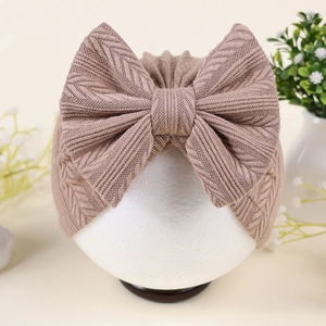 Détail du bonnet turban bébé avec texture côtelée et grand nœud en rose poudré doux