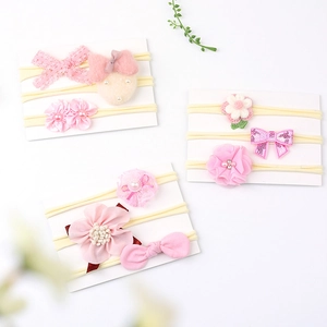 Detailed set of baby headbands with pink lace bows, plush hearts, and floral accents