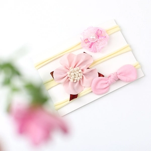 Detailed view of 3-piece pink baby headband set with lace pearls and fabric flowers
