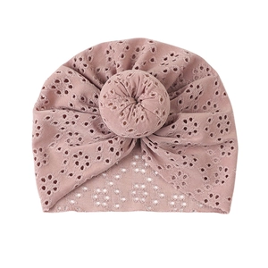 Close-up of baby turban hat showing hollow eyelet embroidery and donut knot detail
