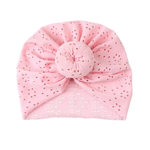 Detailed close-up of light pink lace hollow baby donut turban with breathable knit patterns