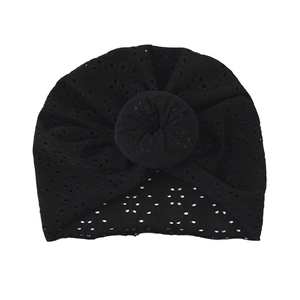 Detailed close-up of a black hollow lace baby turban hat with a stylish top donut knot
