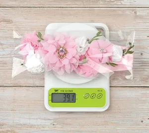 Detail shot of pink and white floral sash weight showing 39.1g on a digital scale