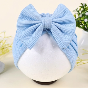 Détail du turban bleu clair pour bébé avec motif de blé et grand nœud décoratif