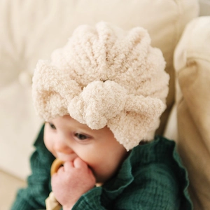 Bonnet bébé en polaire peluche crème avec un grand nœud pour la chaleur hivernale