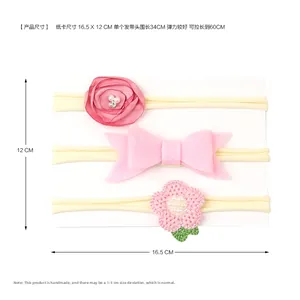 Detail showing three pink baby headbands with floral and bow designs on a display card