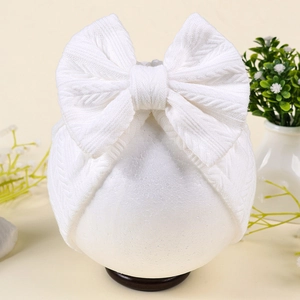 Gros plan d'un bandeau blanc pour bébé avec un grand nœud et une texture en maille