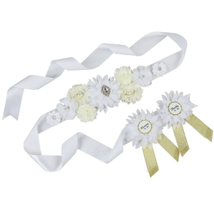 Detail of baby shower sash with fabric flowers and Mommy To Be Daddy To Be badges