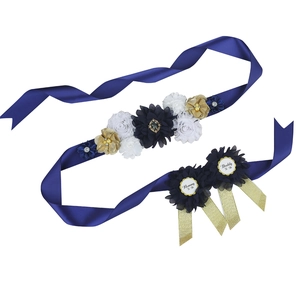 Detail of baby shower flower sash and badges set with pearls and rhinestones for mommy to be