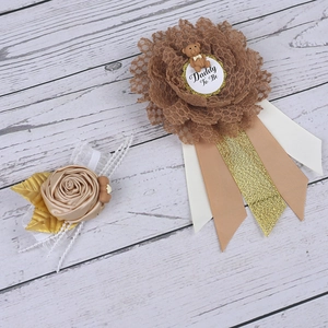 Detail of Daddy To Be baby shower badge with champagne satin rose and bear decoration