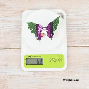 Weight detail of Halloween bat wing bow hair clip with ghost and pumpkin charms