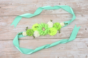 Close-up of maternity flower sash with mint green chiffon roses and crystal accents
