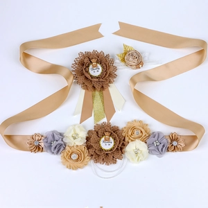Detail of baby shower sash set with champagne fabric flowers and cute teddy bear badges