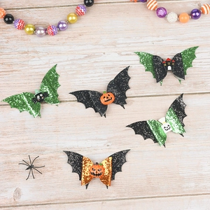 Detail of Halloween hair clips with bat wings, pumpkin charms and glitter sequins