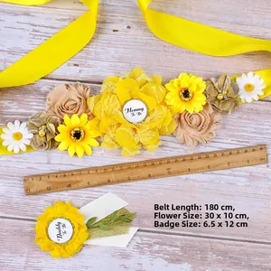 Close-up of yellow sunflower mommy to be sash and daddy to be badge on wood background