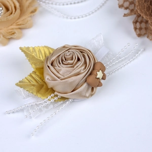 Detail of champagne satin rose waist belt with gold leaves and white pearl tassels