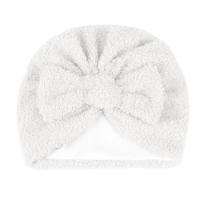 Détail du bonnet pour bébé en polaire teddy blanche avec nœud et doublure douce