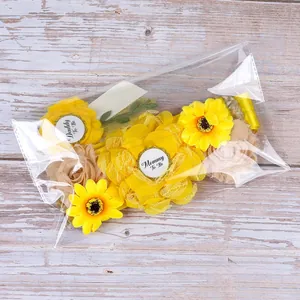 Detail of Mommy To Be and Daddy To Be sunflower corsage badges in clear packaging