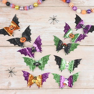 Flat lay of colorful glittery bat wing hair clips with festive Halloween resin charms