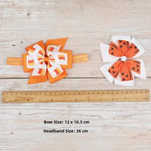 Detail view of Halloween themed candy corn and pumpkin bow headbands on a wooden ruler