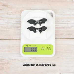 Macro view of black leather bat hair clips set showing 12g weight on electronic scale