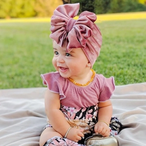 Infant velvet turban hat featuring a large oversized bow in soft dusty pink color